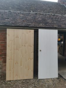 Two doors leaning against a garage
