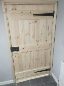 Pine door with black metal hinges