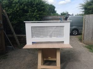 Wooden radiator cover being painted white