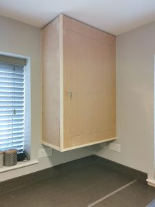 An unpainted wooden kitchen cabinet