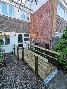 A wooden ramp leading into a terraced house