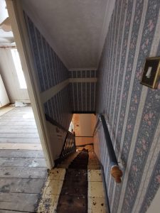 A staircase with blue floral wallpaper