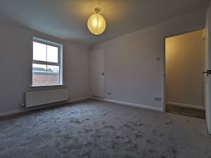 A room with white walls and grey carpet