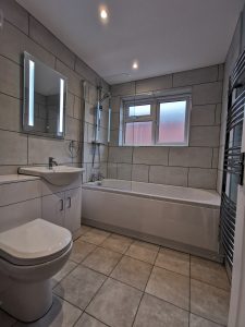 A beautiful bathroom with grey tiles and white fittings