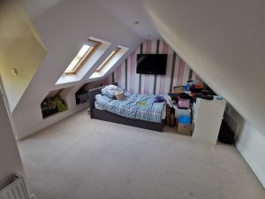 A loft bedroom with striped wallpaper