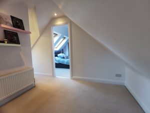 A loft room with a doorway into another room
