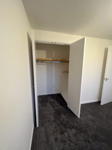 A newly finished room with an open built in wardrobe