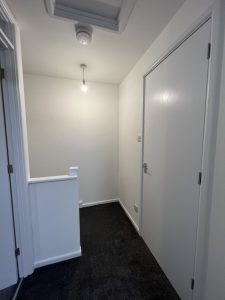 A newly finished hallway with grey carpet and white walls