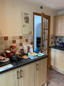 Kitchen with brown cupboards and mixed orange tiles
