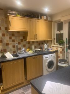 Kitchen with brown cupboards and mixed orange tiles