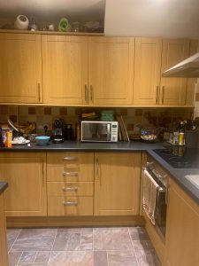 Kitchen with brown cupboards and mixed orange tiles