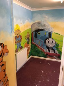 A room with a mural painted with children's characters