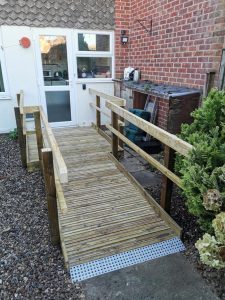 A wooden ramp leading into a terraced house