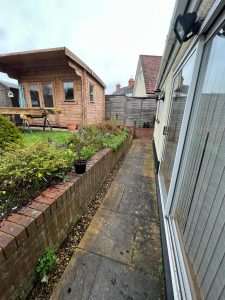 A garden with a bungalow and a shed in view